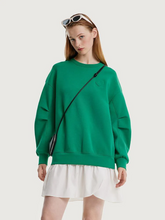 a lady in a green sweatshirt dress paired with a handbag